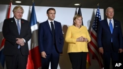 From left, British Prime Minister Boris Johnson, French President Emmanuel Macron, German Chancellor Angela Merkel and U.S. President Joe Biden pose for a photo at the G-20 summit in Rome, Italy, Oct. 30, 2021.
