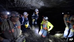 FILE - In this Jan. 13, 2015 file photo, Joe Main, third from left, Assistant Secretary of Labor for Mine Safety and Health, and Patricia Silvey, center, Deputy Assistant Secretary for Operations with MSHA, speak with workers at the Gibson North mine, in Princeton, Indiana. 