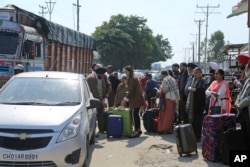 Stranded passengers stand outside an airport after it was closed for civilians operations amid tension along the border with Pakistan in Jammu, India, Feb. 27, 2019.