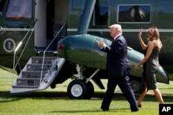 President Donald Trump gestures to onlookers as he walks with first lady Melania Trump to board Marine One on the South Lawn of the White House, Sept. 8, 2017.