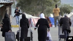 A Libyan family make their way to the terminal at the airport in Tripoli, Libya, March 17, 2011