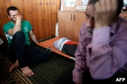 Relatives of 18-month-old Palestinian toddler Ali Saad Dawabsha, who died after his house was set on fire by Jewish settlers, mourn next to his body lying at a mosque during his funeral in the West Bank village of Duma, July 31, 2015.