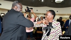 La ministre de la défense Angelina Teny utilise son coude pour saluer le premier vice-président du Soudan du Sud, Riek Machar, son mari, à Juba, le 16 mars 2020.