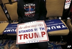 Pablo Ramos, of Orlando, holds a campaign sign as he waits for Republican presidential candidate Donald Trump to speak prior to a campaign event in Tampa, Fla., March 14, 2016.