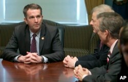 FILE - Virginia Gov. Ralph Northam, left, address State Senators and Delegates as they gather to inform him that they are ready to adjourn the 2018 session of the Virginia General Assembly at the Capitol in Richmond, Va., March 10, 2018.