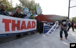 Protesters carry a mock missile symbolizing an advanced U.S. missile defense system called Terminal High-Altitude Area Defense, or THAAD, during a rally to oppose a plan to deploy the THAAD in front of the Defense Ministry in Seoul, South Korea, Oct. 20, 2016.