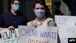 Protesters hold signs as they gather during a rally for Uyghur Freedom in New York, March 22, 2021. 