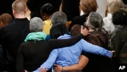 FILE - Mourners at the National Cathedral in Washington.embrace at a vigil for victims of the shootings at Sandy Hook Elementary School in Newtown, Conn., Dec. 12, 2013.