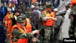 Wafanyakazi wa uokozi wanaonekana kwenye eneo lililokumbwa na maporomoko nchini China siku ya Jumamosi tarehe 24 Juni, 2017. 