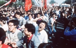 FILE - Students shout after breaking through a police blockade during a pro-democracy march to Tiananmen Square, Beijing, May 4, 1989.