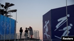 FILE - Members of the media work during the rehearsal of a medal ceremony at the Medals Plaza of the Beijing 2022 Winter Olympics in Beijing, China, Jan. 3, 2022.