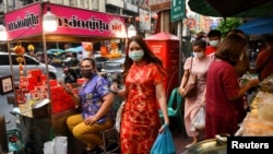 People walk on the street as they prepare for the Lunar New Year celebration at the Chinatown in Bangkok, Thailand, Feb. 10, 2021.