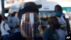 People wear face masks to protect against COVID-19 before boarding a minibus taxi in Johannesburg, Dec. 24,2020.