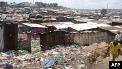 FILE - A man walks by the slum of Mathare, one of the poorest slums in Nairobi, May 28, 2014. 