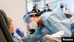 An air traveler takes a coronavirus disease (COVID-19) test before boarding an El Al flight to Israel at JFK International Airport in New York, August 5, 2021.