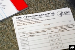 Kartu catatan vaksinasi COVID-19 ditunjukkan di Seton Medical Center di Daly City, California (Foto: AP)
