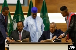 FILE - Redwan Hussien Rameto, 2nd left, representative of the Ethiopian government, and Getachew Reda, 2nd right, representative of the Tigray People's Liberation Front (TPLF), sign a peace agreement in Pretoria, Nov. 2, 2022.