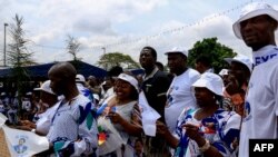 FILE - Supporters of Cameroonian President Paul Biya wear clothing emblazoned with his image as they celebrate his re-election in Yaoundé on Nov. 6, 2018.