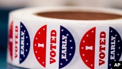 FILE — "I VOTED EARLY' stickers sit at a Milwaukee polling station, Oct. 25, 2022. Most states have found common ground in allowing early in-person voting. Today, 46 states and the District of Columbia allow early voting.