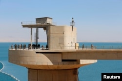 FILE - Peshmerga fighters stand guard at Mosul Dam in northern Iraq, Aug. 21, 2014. Mosul and the area down river are currently largely controlled by Islamic State militants.