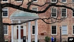FILE - People remove belongings on campus at the University of North Carolina in Chapel Hill, N.C., March 18, 2020.