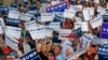 Audience members hold up signs supporting Republican presidential candidate Donald Trump during a campaign rally in Boca Raton, Florida, March 13, 2016. 