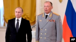 FILE - In this photo taken on March 17, 2016, Russian President Vladimir Putin, left, poses with Col. Gen. Alexander Dvornikov during an awarding ceremony in Moscow's Kremlin. (Alexei Nikolsky/Sputnik, Kremlin Pool Photo via AP)