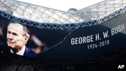 A tribute for Former President George H.W. Bush is seen before the first half of an NFL football game between the Atlanta Falcons and the Baltimore Ravens, Dec. 2, 2018, in Atlanta. 