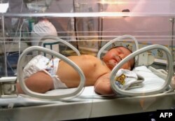 Seorang bayi tidur di dalam inkubator di rumah sakit Fatmawati, Jakarta, 05 Desember 2007. Sang ibu, Ernawati, melahirkan bayi terberat di Indonesia, bayi laki-laki dengan berat 6,9 kilogram. Ibu berusia 37 tahun itu menderita diabetes gestasional, yang membuat bayi berisiko menjadi lebih berat dari biasanya. (Foto oleh Adek BERRY/AFP)