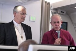 Archbishop of Canterbury Justin Welby (R) and Church of Scotland's Iain Greenshields address the media while aboard the Pope's plane from Juba to Rome, Feb. 5, 2023