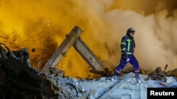 An emergency specialist walks among debris at the site where a building was heavily damaged in recent shelling during the Russia-Ukraine conflict in Donetsk, Russian-controlled Ukraine, Jan. 16, 2023. 