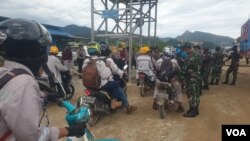 Personel TNI-POLRI melakukan pemeriksaan terhadap pekerja yang hendak memasuki pabrik smelter PT GNI di Morowali Utara, Sulawesi Tengah, 19 Januari 2023 (Foto : VOA/Yoanes Litha)