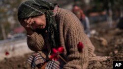 A member of the Vehibe family mourns a relative during the burial of a victim of the earthquakes that struck a border region of Turkey and Syria five days ago in Antakya, southeastern Turkey, Feb. 11, 2023.