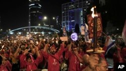 Israelis carry torches at a protest against Israeli Prime Minister Benjamin Netanyahu and his far-right government that his opponents say threaten democracy and freedoms, in Tel Aviv, Israel, Jan. 21, 2023.