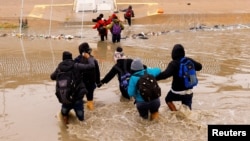 Migrantes que buscan asilo cruzan el río Bravo, la frontera entre Estados Unidos y México, para solicitar asilo en El Paso, visto desde Ciudad Juárez, México, el 2 de enero de 2023.