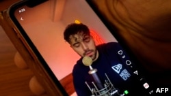 FILE - A man watches a video of Iranian singer Shervin Hajipour, in the Cypriot capital Nicosia, Oct. 4, 2022. 