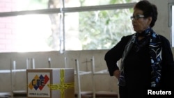 FILE - An electoral worker awaits voters at a polling station during local elections in Caracas, Venezuela, Dec. 9, 2018.