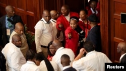 Opposition Economic Freedom Fighters party members react after they were removed from the national assembly during South African President Cyril Ramaphosa's State of the Nation address at parliament in Cape Town, South Africa, Feb. 9, 2023.