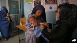FILE - In this Aug. 26, 2019, photo, a health worker measures the arm of a malnourished boy at a UNICEF clinic in Jabal Saraj north of Kabul, Afghanistan. 