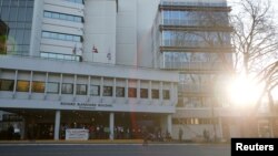 FILE - Protesters stand outside the Ministry of Health as part of a demonstration against the Coastal GasLink pipeline, in Victoria, British Columbia, Feb. 14, 2020.