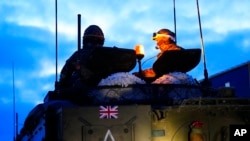 FILE - Britain's military officers sit on top of an armored vehicle at the Tapa Military Camp, in Estonia, Jan. 19, 2023. 