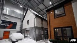 Simulated snow covers a car and the walls of one of two houses built to develop future heating solutions, at Energy House 2.0 in Salford, UK, Jan. 24, 2023.