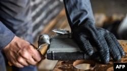 A worker prepares molds of plastic waste at a startup company about 60 kilometers east of Egypt's capital, on Dec. 8, 2022.