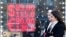 People walk past a currency exchange office screen displaying the exchange rates of US dollars and Euro to Russian rubles in Moscow, Feb. 28, 2022. 