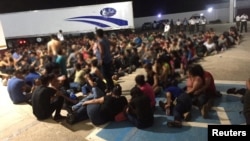 Migrants are pictured outside an abandoned truck trailer where Mexican authorities found 343 migrants from Central America, including 103 unaccompanied minors mostly from Guatemala inside in the eastern state of Veracruz, Mexico March 5, 2023. 