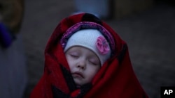 Three-year-old Anna sleeps on a chair after fleeing from Ukraine with her brother and mother at the border crossing in Medyka, Poland, March 5, 2022.