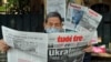 FILE - A man reads a Vietnamese newspaper featuring front-page coverage of the Russian invasion of Ukraine at a stall in Hanoi, Feb. 25, 2022.