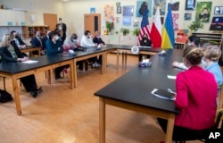 U.S. Vice President Kamala Harris, center, holds a roundtable discussion with people displaced from Ukraine at the American School of Warsaw, in Warsaw, Poland, March 10, 2022