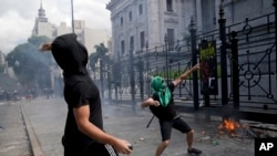 Manifestantes lanzan piedras frente al Congreso en Buenos Aires, Argentina, mientras los legisladores se preparan para ratificar el acuerdo del gobierno con el Fondo Monetario Internacional para refinanciar unos 45.000 millones de dólares en deuda el 10 de marzo de 2022.