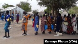 Displaced people in the town of Bor, South Sudan, collect food aid last month. (Kate Bartlett/VOA)